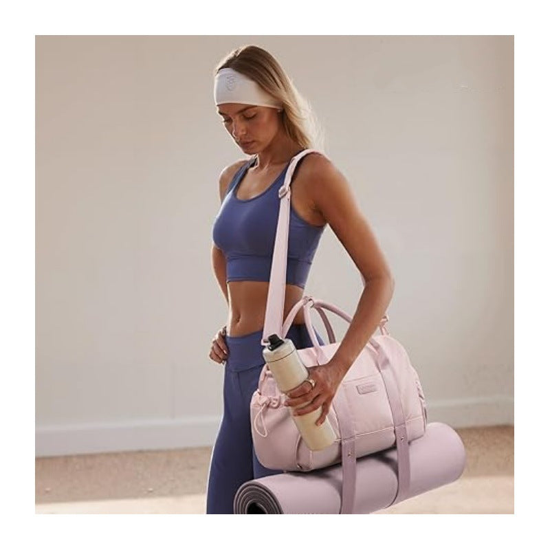 Woman carrying the featherlight gym bag with yoga mat strapped underneath